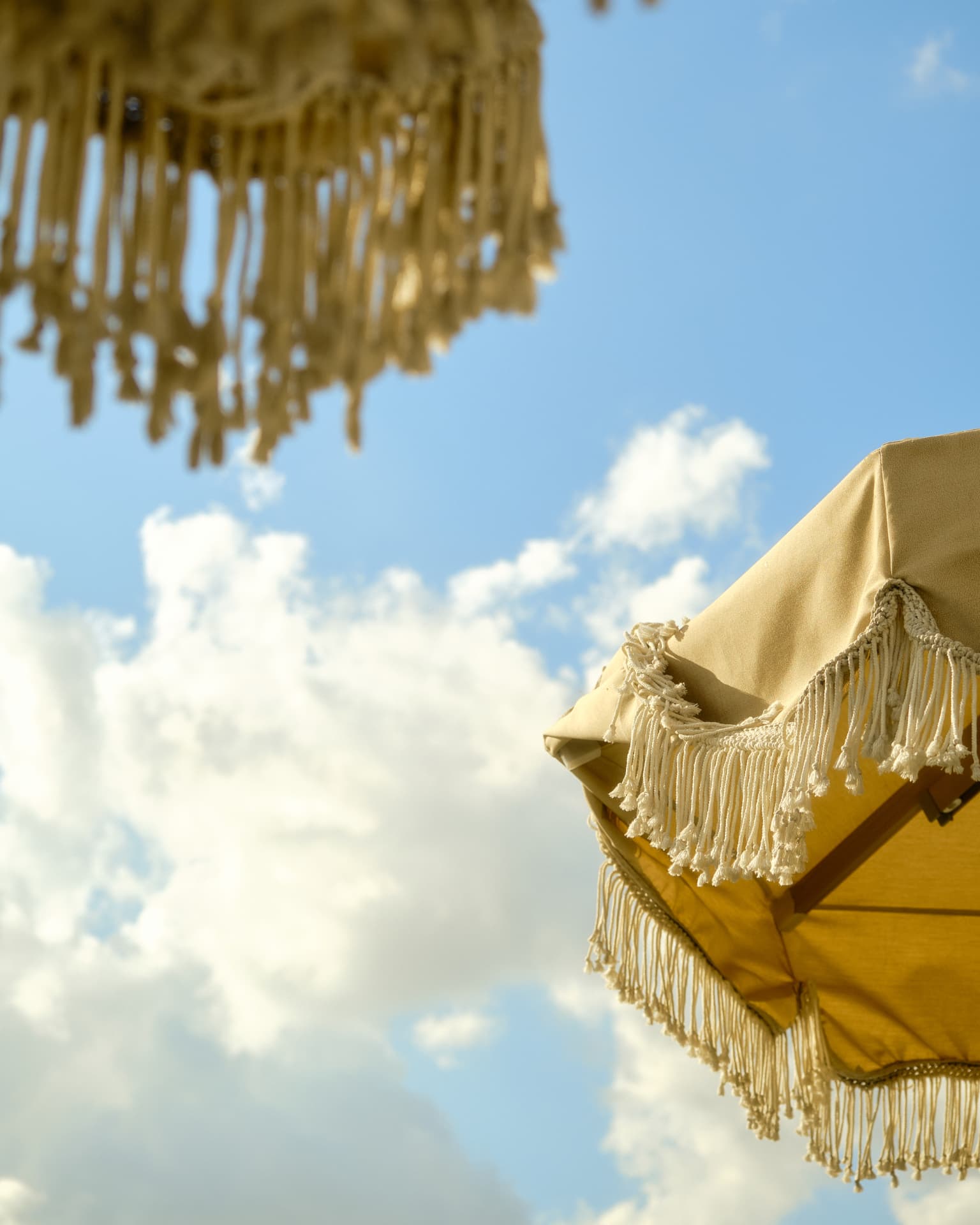 Fringed parasols against a blue sky above the rooftop terrace